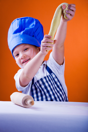 Boy chef kneading dough